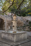 Le Beaucet.<br> Cette fontaine du XIXe siècle comporte un bassin de forme hexagonale. Le fût octogonal présente en acrotère un vase Médicis surmonté d’une pomme de pin. Les quatre mascarons desquels partent les canons représentaient deux visages (remplacés suite à un vol en 1999) et deux rosaces.
Les canalisations ont été nettoyées et les décors en acrotère resculptés lors de la restauration de la fontaine en 2004.